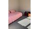 Bright bedroom with pink comforter, and natural sunlight at 16015 Cape Coral Dr, Wimauma, FL 33598