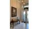Bright foyer features decorative glass double-doors and travertine floors at 16015 Cape Coral Dr, Wimauma, FL 33598