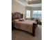 Spacious main bedroom features large bed, bedside tables, lake views, and an abundance of natural light at 16015 Cape Coral Dr, Wimauma, FL 33598