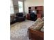 Bright office featuring a wooden desk, black office chair, leather chair, and a patterned rug on a hardwood floor at 16015 Cape Coral Dr, Wimauma, FL 33598