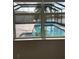 View from interior shows screened-in lanai with inviting pool and beautiful lake view at 16015 Cape Coral Dr, Wimauma, FL 33598