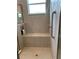 Walk-in shower with bench, shower head, handheld sprayer, and built-in shelf at 16015 Cape Coral Dr, Wimauma, FL 33598