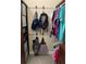 Functional walk-in closet with hanging rods, shelving, and a variety of bags and accessories organized at 16015 Cape Coral Dr, Wimauma, FL 33598