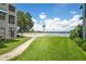 View from backyard of grassy lawn with walk path to the community lake at 3127 W Sligh Ave # 204B, Tampa, FL 33614