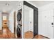 Hallway with laundry area, entry door, and closet with a large mirror at 3127 W Sligh Ave # 204B, Tampa, FL 33614