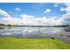 Community lake and sky in the background with a grassy lawn in the foreground on a sunny day at 3127 W Sligh Ave # 204B, Tampa, FL 33614