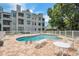 Community pool for residents and guests on a sunny day surrounded by lounge chairs and tables at 3127 W Sligh Ave # 204B, Tampa, FL 33614