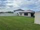 Backyard view featuring a white fence, green grass, and solar panels on the roof at 7119 Salt River Ave, Sun City Center, FL 33573