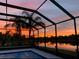 Screened-in pool with sunset view at 16015 Cape Coral Dr, Wimauma, FL 33598
