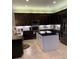 Modern kitchen featuring dark cabinetry, granite countertops, and an island at 16015 Cape Coral Dr, Wimauma, FL 33598