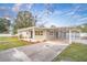 Newly built home with gray exterior, covered carport, and landscaped yard at 10112 Midway St, Gibsonton, FL 33534