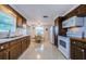 Galley kitchen with wood cabinets and white appliances at 1551 Derrick St, Holiday, FL 34690