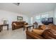 Living room with brown couches, coffee table, and TV at 1551 Derrick St, Holiday, FL 34690