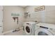 Functional laundry room with washer, dryer, and ample shelving at 19855 Magnolia Springs Way, Land O Lakes, FL 34638