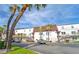 Two-story white apartment building with parking in front and palm trees at 9205 Tudor Dr # C209, Tampa, FL 33615
