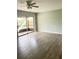 Living room with sliding doors to balcony and wood-look floors at 9205 Tudor Dr # C209, Tampa, FL 33615