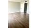 Bright bedroom with wood-look floors and an open door to a hallway at 9205 Tudor Dr # C209, Tampa, FL 33615