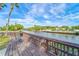 Relaxing waterfront view with a wooden deck, bench, and lush greenery at 9205 Tudor Dr # C209, Tampa, FL 33615