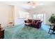 Living room featuring a maroon sofa, a glass coffee table, and sliding glass doors at 11111 Dormie Dr, San Antonio, FL 33576