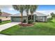 Single-story house with green walls, gray roof, and palm trees at 11111 Dormie Dr, San Antonio, FL 33576