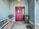 Inviting entryway with a burgundy door, a tiled floor, and potted plants at 11111 Dormie Dr, San Antonio, FL 33576