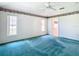 Bright bedroom featuring teal carpeting and a view of the bathroom at 11111 Dormie Dr, San Antonio, FL 33576
