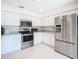Stainless steel appliances and white cabinets in kitchen at 11111 Dormie Dr, San Antonio, FL 33576
