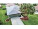 Single-story house with green walls, gray roof, and palm trees at 11111 Dormie Dr, San Antonio, FL 33576