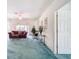 Living room with teal carpet, a maroon sofa, and a rocking chair at 11111 Dormie Dr, San Antonio, FL 33576