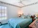 Bedroom with teal bedding and large window, offering natural light at 11111 Dormie Dr, San Antonio, FL 33576