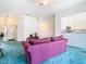 Living room with teal carpet, maroon sofa and kitchen views at 11111 Dormie Dr, San Antonio, FL 33576