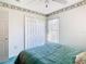 Well-lit bedroom with double closet and teal bedding at 11111 Dormie Dr, San Antonio, FL 33576