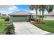 Single-story house with green walls, gray roof, and palm trees at 11111 Dormie Dr, San Antonio, FL 33576