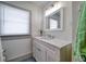 Clean bathroom with white vanity, marble countertop, and patterned floor at 963 Highland Ave, Dunedin, FL 34698