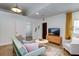 Living room with green sofa, TV, and view into dining area at 963 Highland Ave, Dunedin, FL 34698