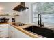 Modern kitchen with white cabinets, butcher block countertops, and black appliances at 963 Highland Ave, Dunedin, FL 34698