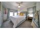 Bright bedroom with a gray upholstered bed and two windows at 963 Highland Ave, Dunedin, FL 34698