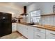 Modern kitchen with white cabinets, butcher block countertops, and black appliances at 963 Highland Ave, Dunedin, FL 34698