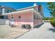 Pink house exterior showcasing a side view with AC units and gravel driveway at 963 Highland Ave, Dunedin, FL 34698