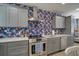 Modern kitchen with grey cabinets, stainless steel appliances, and tropical wallpaper at 963 Highland Ave, Dunedin, FL 34698