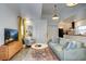 Living room features a green velvet couch, a media console, and a round coffee table at 963 Highland Ave, Dunedin, FL 34698