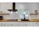 Modern kitchen with white cabinets, butcher block countertops, and black appliances at 963 Highland Ave, Dunedin, FL 34698
