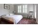 A cozy bedroom featuring hardwood floors, a comfortable bed with floral bedding, and a rocking chair at 1408 W Azeele St, Tampa, FL 33606