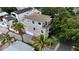 Aerial view of a three-story gray home showcasing a charming balcony, palm trees, and lush greenery at 1408 W Azeele St, Tampa, FL 33606