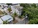 Aerial view of a charming gray home with a balcony, surrounded by lush tropical landscaping and nearby street at 1408 W Azeele St, Tampa, FL 33606