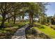 Curving concrete walkway shaded by large trees at 7219 Hamilton Rd # 7219, Bradenton, FL 34209