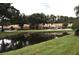 Community view with pond, landscaping and homes at 3230 Jademoor Cir, Palm Harbor, FL 34685