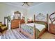 Spacious bedroom with a large bed, dresser, and hardwood floors at 5909 Menorca Ln, Apollo Beach, FL 33572