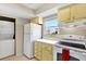 White appliances and yellow cabinets in this galley-style kitchen at 3365 39Th S St # C-1, St Petersburg, FL 33711