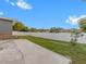 Large backyard with grassy area, white vinyl fence, and a patio at 1009 Cobblestone Dr, Spring Hill, FL 34606